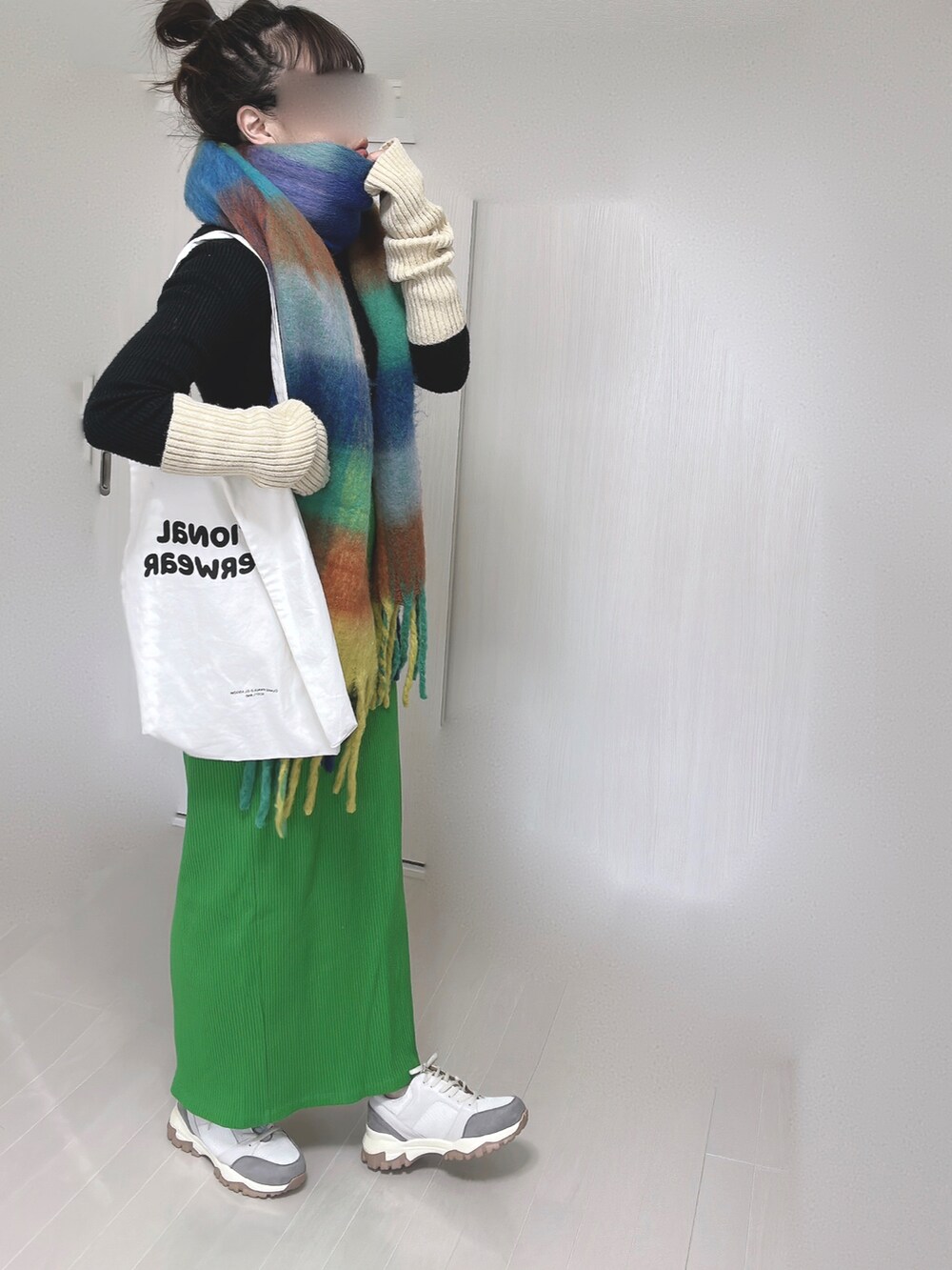 ホワイト系のトートバッグ、グリーン系のスカート、ベージュ系のスニーカーを着用したレディースの冬コーディネートの4枚目の写真