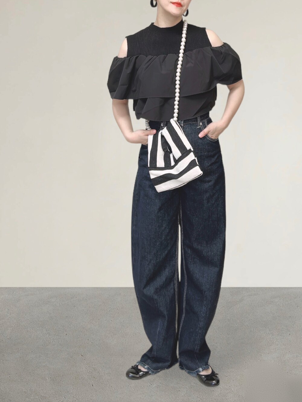 ブルー系のデニムパンツ、ホワイト系のショルダーバッグ、ブラック系のバレエシューズを着用したレディースの秋コーディネートの5枚目の写真