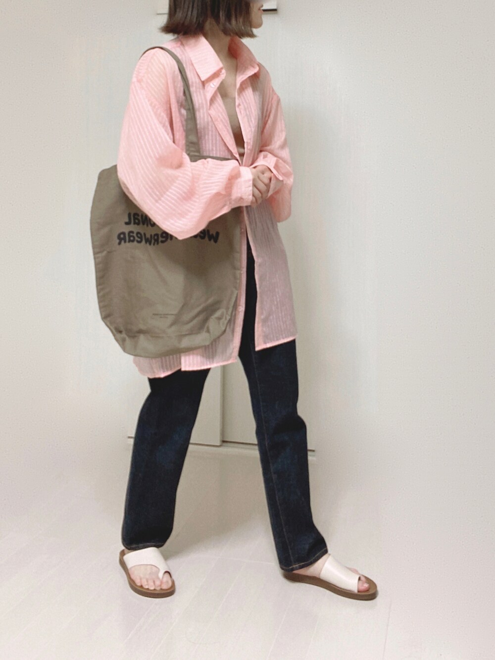 ピンク系のシャツ/ブラウス、ブラウン系のトートバッグ、ブルー系のデニムパンツを着用したレディースの夏コーディネートの3枚目の写真