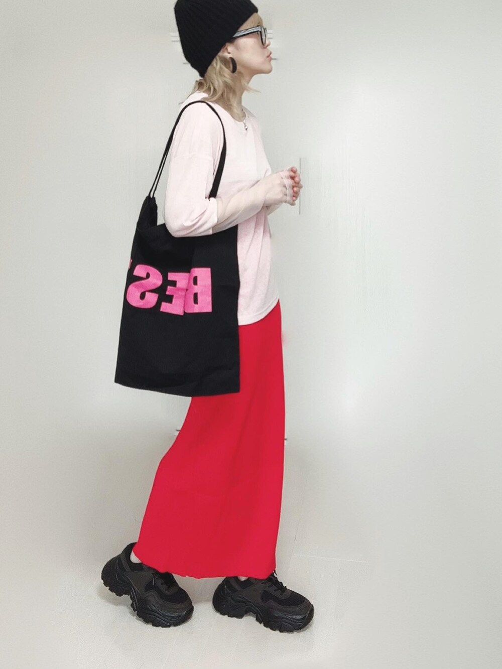 ピンク系のTシャツ/カットソー、ブラック系のトートバッグ、レッド系のスカートを着用したレディースの春コーディネートの2枚目の写真