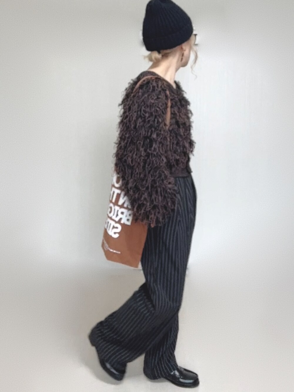 ブラック系のカーディガン/ボレロ、ブラック系のスラックス、ブラック系のローファーを着用したレディースの秋コーディネートの4枚目の写真