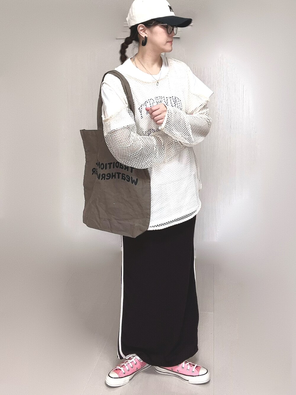 ホワイト系のTシャツ/カットソー、ブラウン系のトートバッグ、ピンク系のスニーカーを着用したレディースの春コーディネートの2枚目の写真