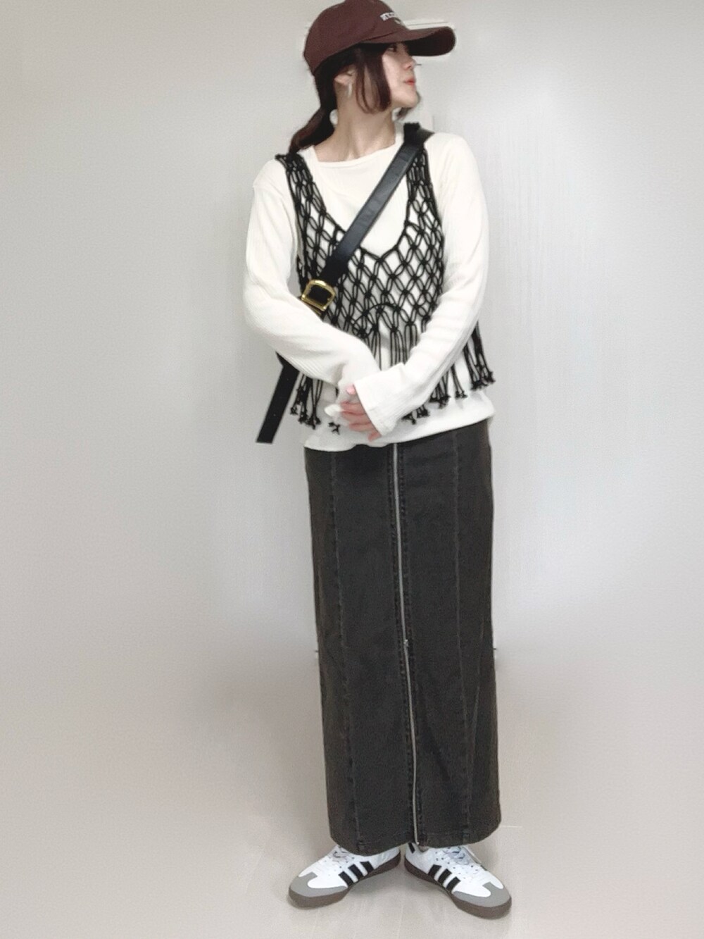 ブラック系のスカート、ベージュ系のTシャツ/カットソー、ブラック系のベストを着用したレディースの春コーディネートの2枚目の写真