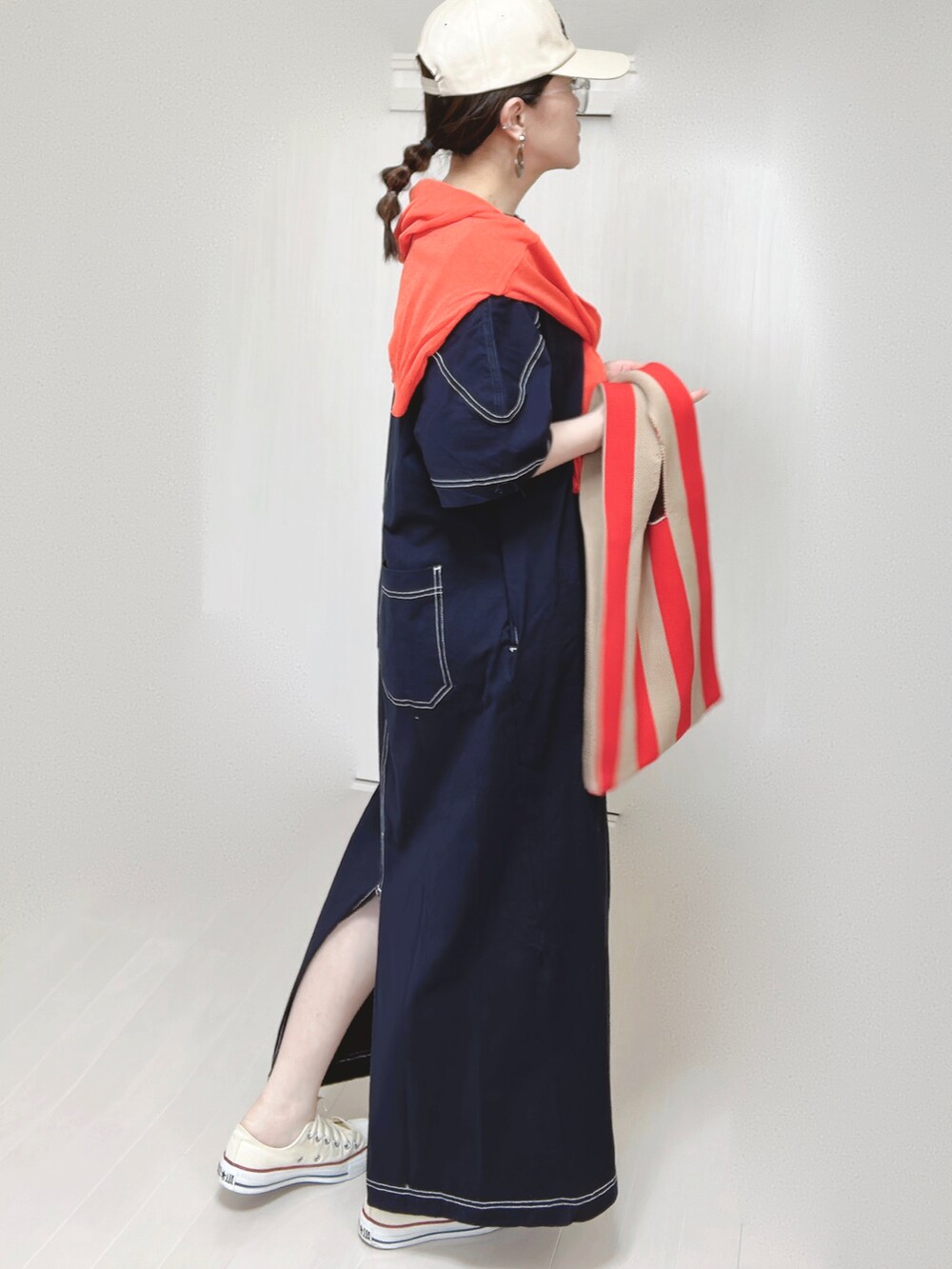 ブルー系のワンピース、オレンジ系のカーディガン/ボレロ、ホワイト系のスニーカーを着用したレディースの春コーディネートの2枚目の写真