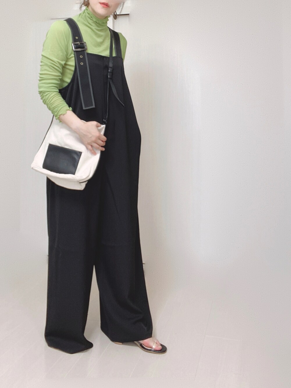 ブラック系のサロペット/オーバーオール、グリーン系のTシャツ/カットソー、ホワイト系のショルダーバッグを着用したレディースの夏コーディネートの3枚目の写真