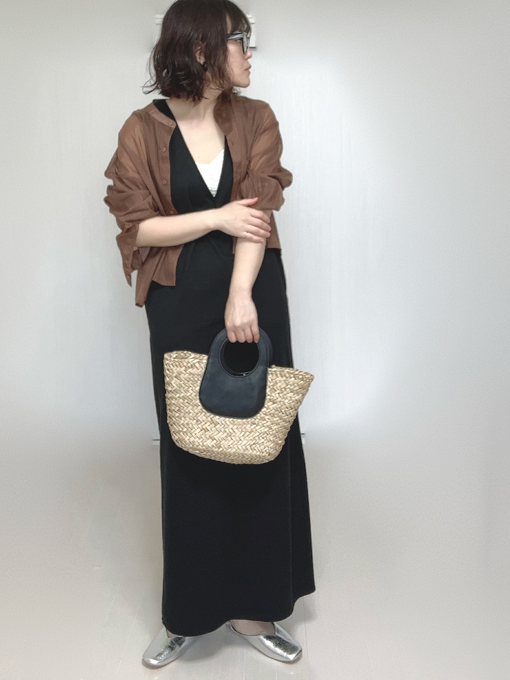 ブラック系のワンピース、ブラウン系のシャツ/ブラウス、シルバー系のパンプスを着用したレディースの春コーディネートの2枚目の写真