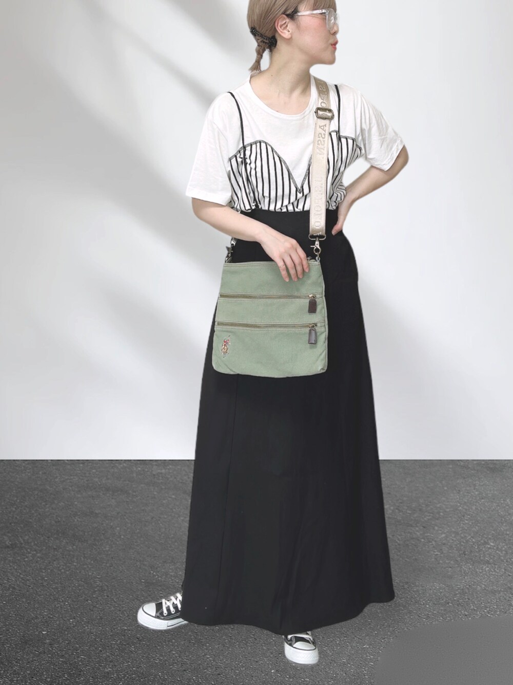 ホワイト系のTシャツ/カットソー、グリーン系のショルダーバッグ、ブラック系のスカートを着用したレディースの秋コーディネートの4枚目の写真