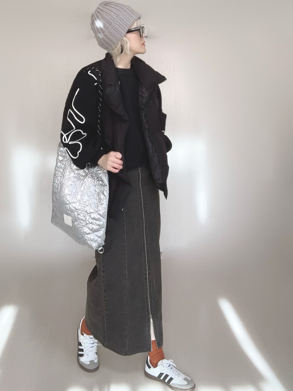 ブラック系のニット/セーター、ブラック系のスカート、ブラック系のダウンベストを着用したレディースの冬コーディネートの2枚目の写真