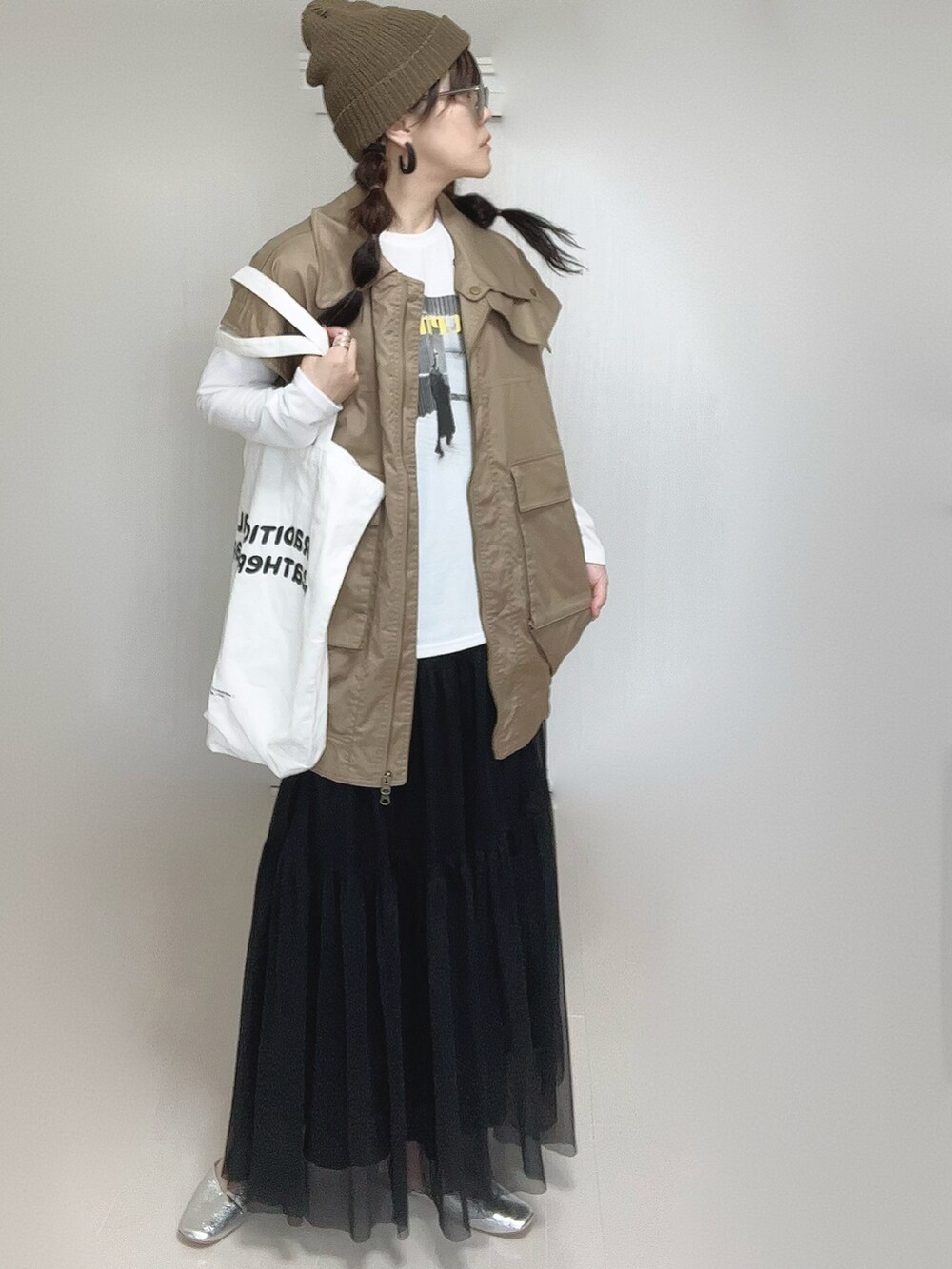 ブラック系のスカート、ホワイト系のTシャツ/カットソー、ベージュ系のジャケット/アウターを着用したレディースの秋コーディネートの2枚目の写真