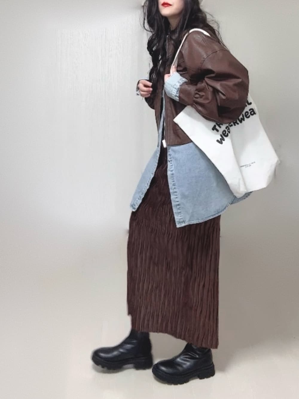 ブルー系のシャツ/ブラウス、ブラウン系のブルゾン、ブラック系のブーツを着用したレディースの冬コーディネートの4枚目の写真