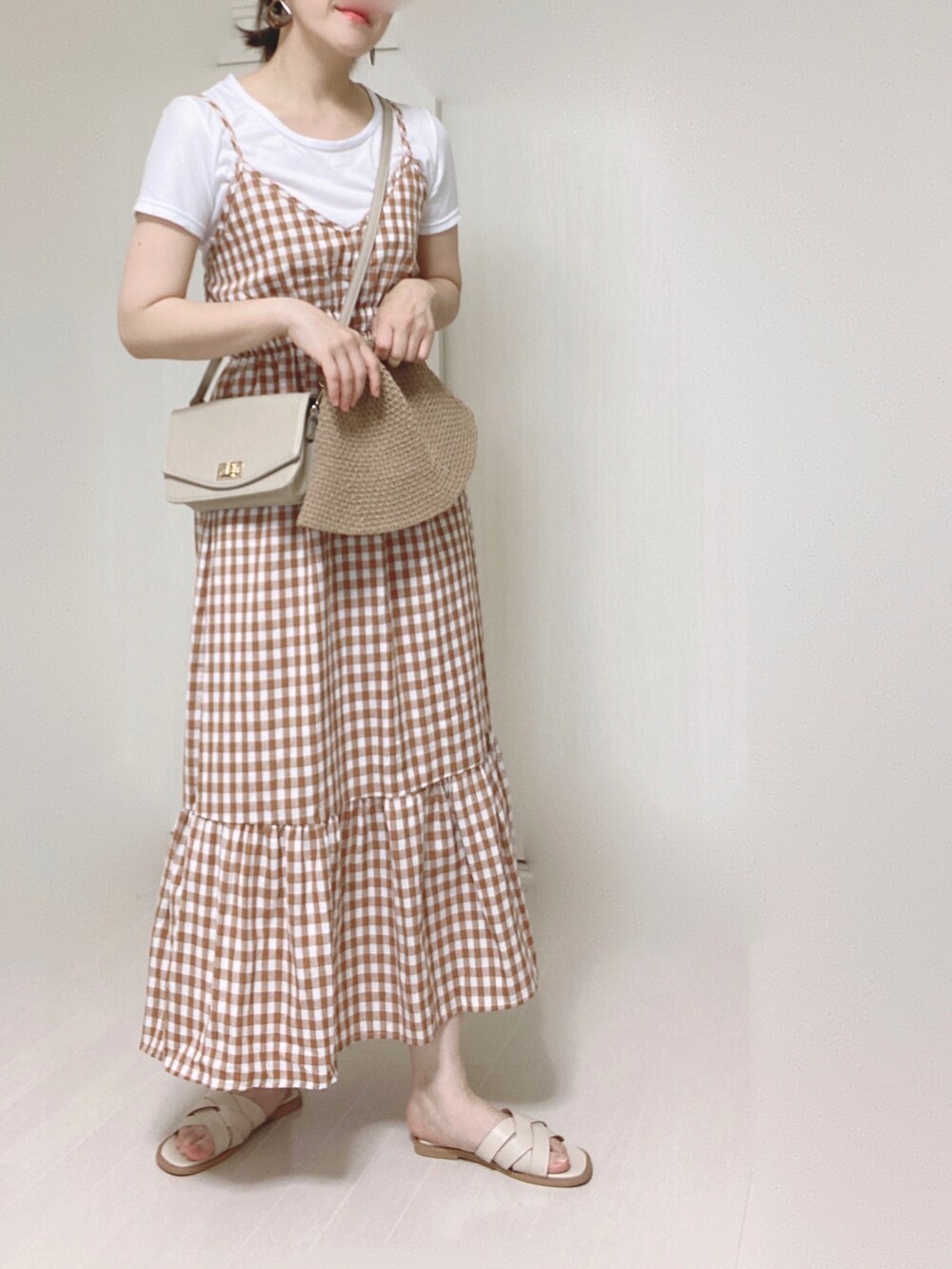 オレンジ系のワンピース、ベージュ系のショルダーバッグ、ホワイト系のサンダルを着用したレディースの夏コーディネートの3枚目の写真