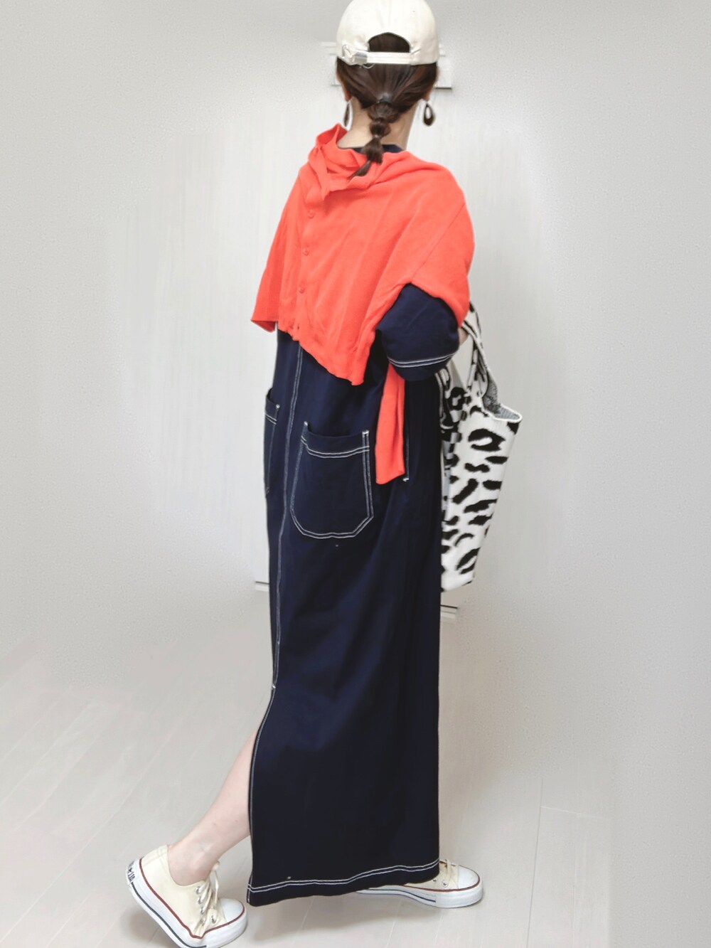 ブルー系のワンピース、オレンジ系のカーディガン/ボレロ、ホワイト系のスニーカーを着用したレディースの春コーディネートの3枚目の写真