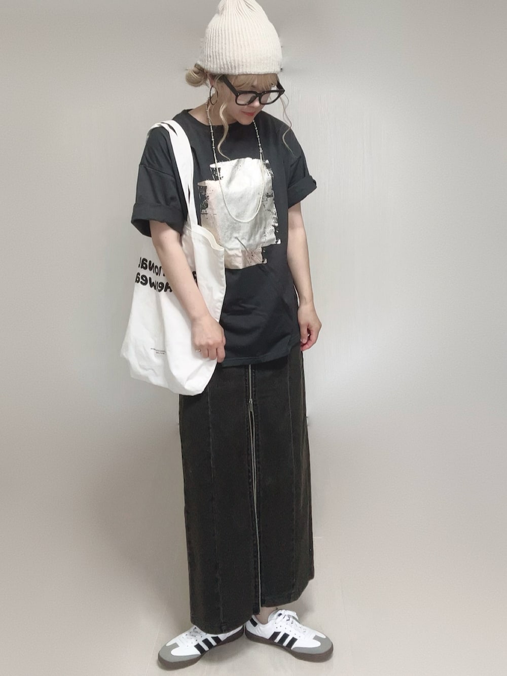 ブラック系のTシャツ/カットソー、ブラック系のスカート、ホワイト系のトートバッグを着用したレディースの夏コーディネートの4枚目の写真