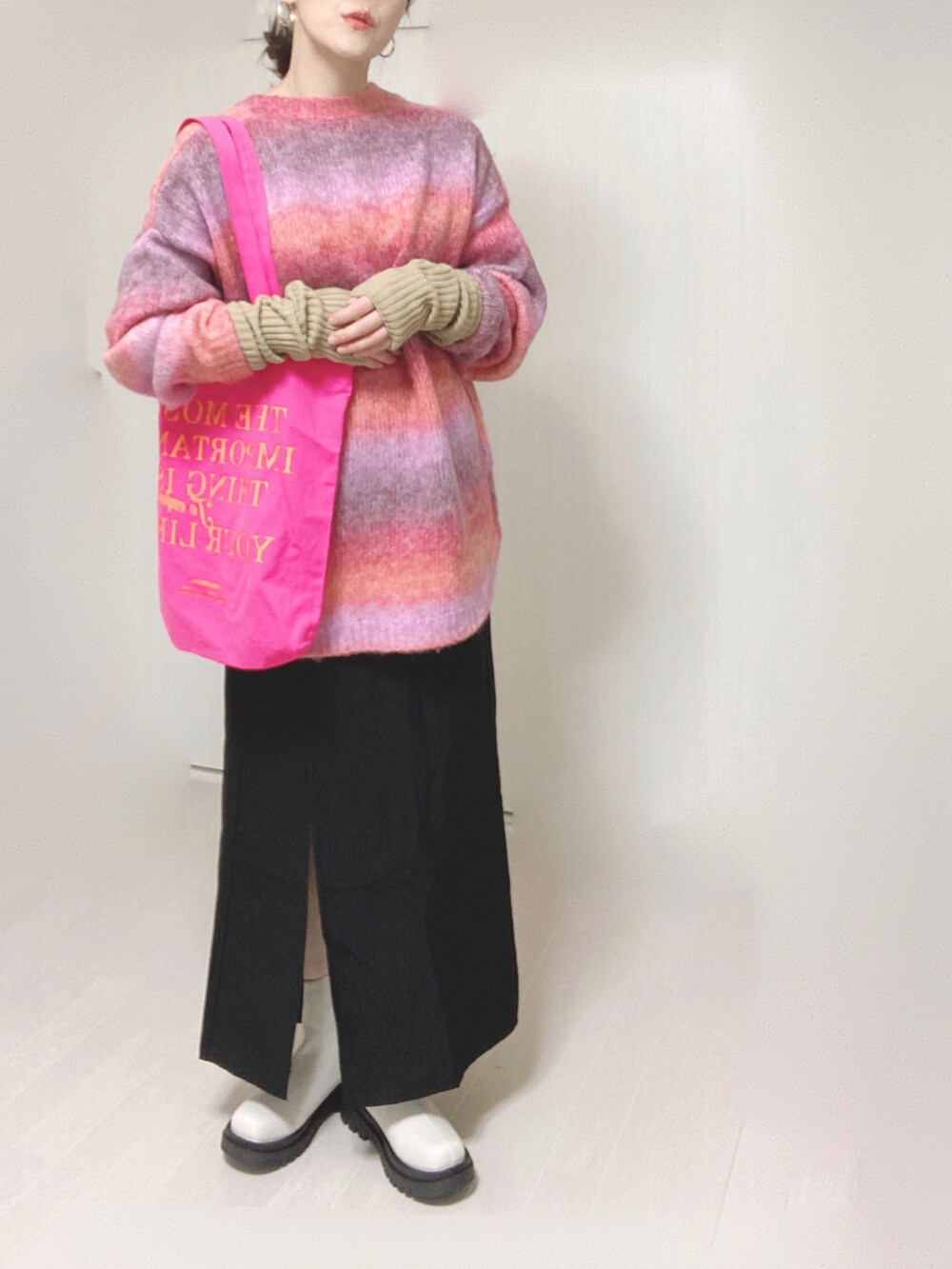 ホワイト系のブーツ、ピンク系のカーディガン/ボレロ、ピンク系のトートバッグを着用したレディースの秋コーディネートの3枚目の写真