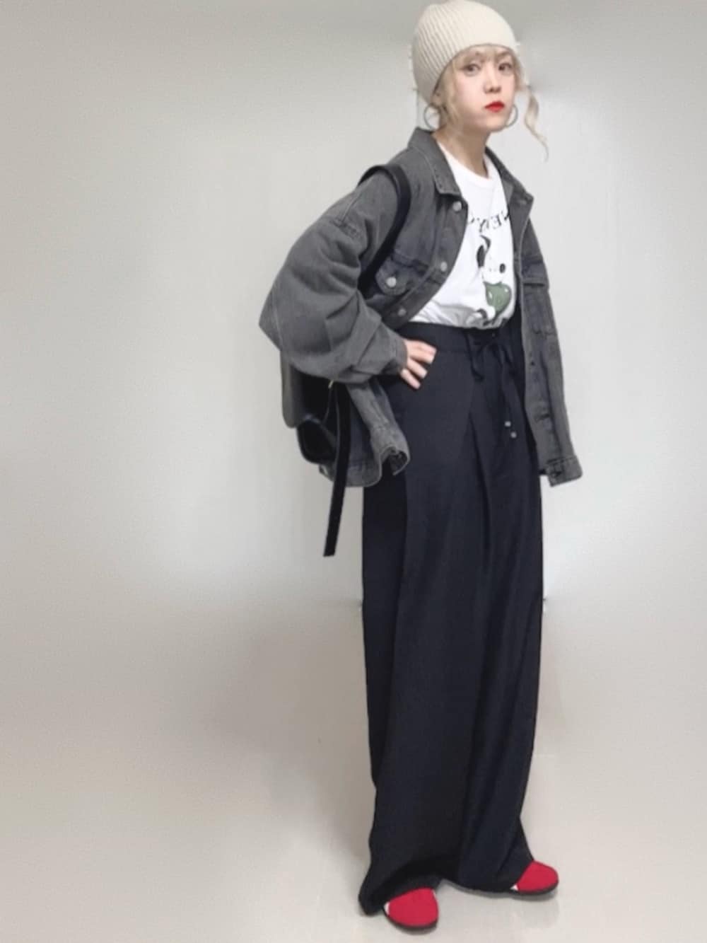 ブラック系のデニムジャケット、ブラック系のスラックス、ホワイト系のTシャツ/カットソーを着用したレディースの冬コーディネートの3枚目の写真