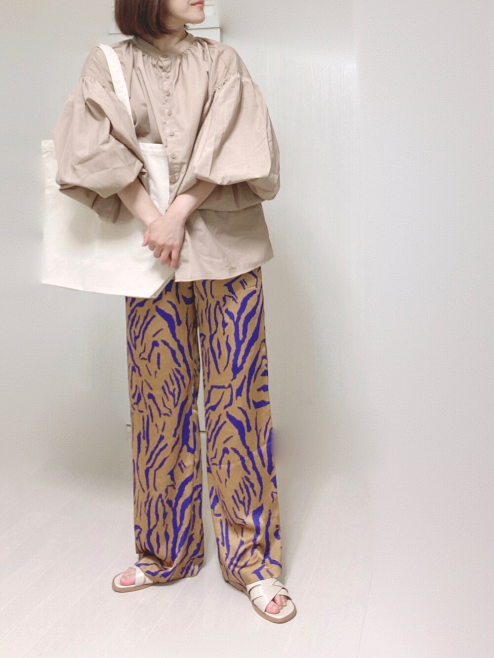 ホワイト系のトートバッグ、ベージュ系のシャツ/ブラウス、オレンジ系のその他パンツを着用したレディースの夏コーディネートの2枚目の写真