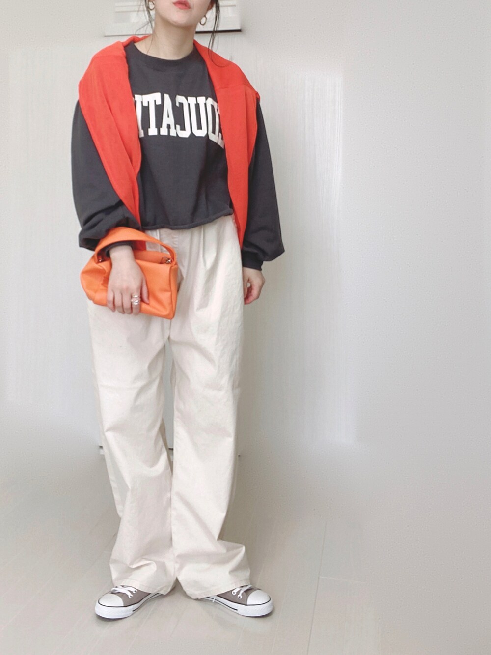 ホワイト系のその他パンツ、オレンジ系のカーディガン/ボレロ、オレンジ系のショルダーバッグを着用したレディースの春コーディネートの3枚目の写真