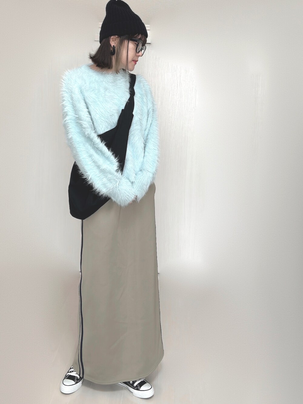 ブルー系のニット/セーター、ブルー系のスカート、ブラック系のスニーカーを着用したレディースの秋コーディネートの5枚目の写真