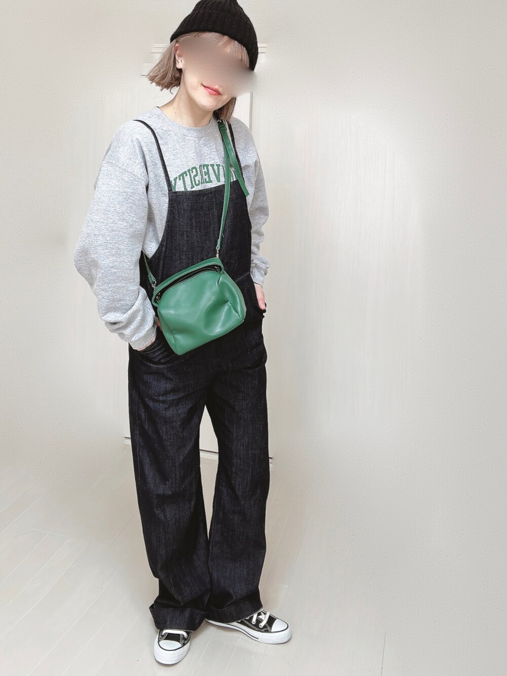 ブルー系のサロペット/オーバーオール、グレー系のスウェット、グリーン系のハンドバッグを着用したレディースの春コーディネートの3枚目の写真