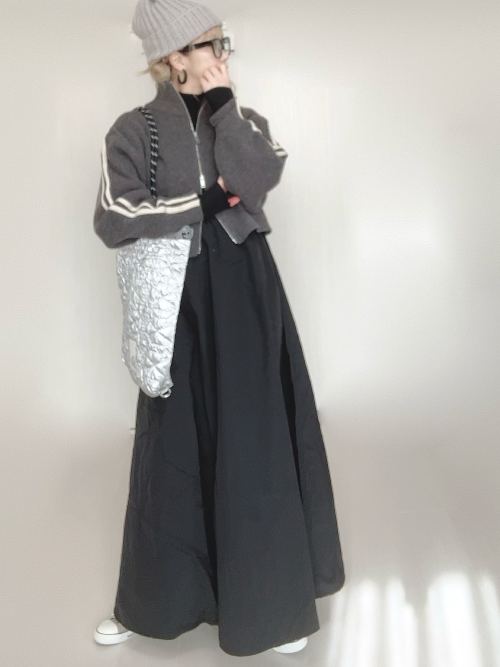 グレー系のニット/セーター、グレー系のワンピース、シルバー系のトートバッグを着用したレディースの冬コーディネートの4枚目の写真