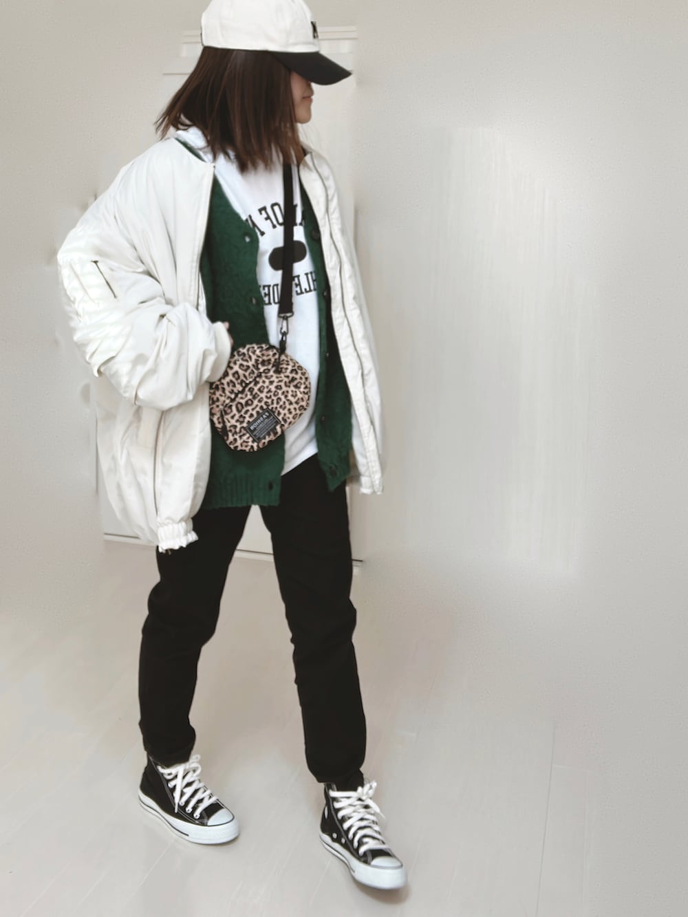 ホワイト系のTシャツ/カットソー、ホワイト系のブルゾン、グリーン系のカーディガン/ボレロを着用したレディースの冬コーディネートの3枚目の写真