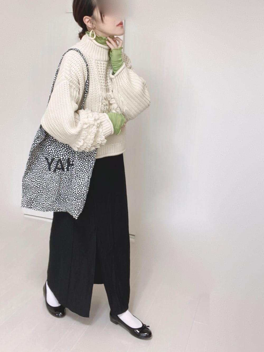 ホワイト系のニット/セーター、ブラック系のスカート、グリーン系のTシャツ/カットソーを着用したレディースの秋コーディネートの4枚目の写真