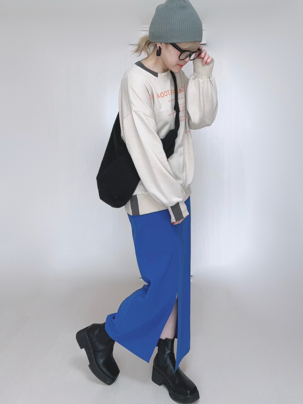 ベージュ系のスウェット、ブルー系のスカート、ブラック系のブーツを着用したレディースの冬コーディネートの5枚目の写真