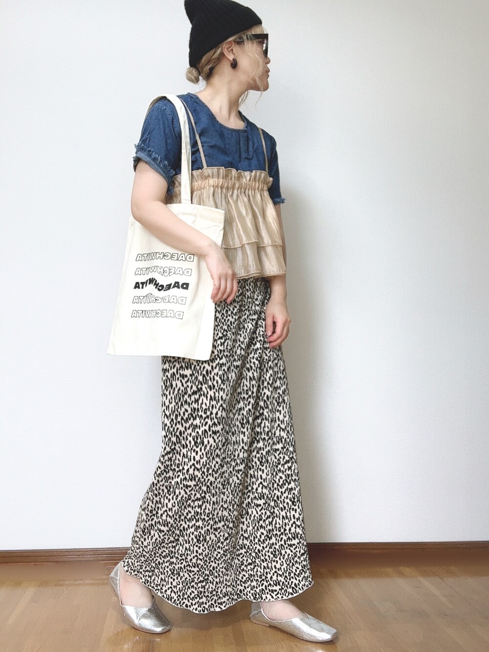 オレンジ系のキャミソール、ベージュ系のスカート、シルバー系のパンプスを着用したレディースの夏コーディネートの4枚目の写真