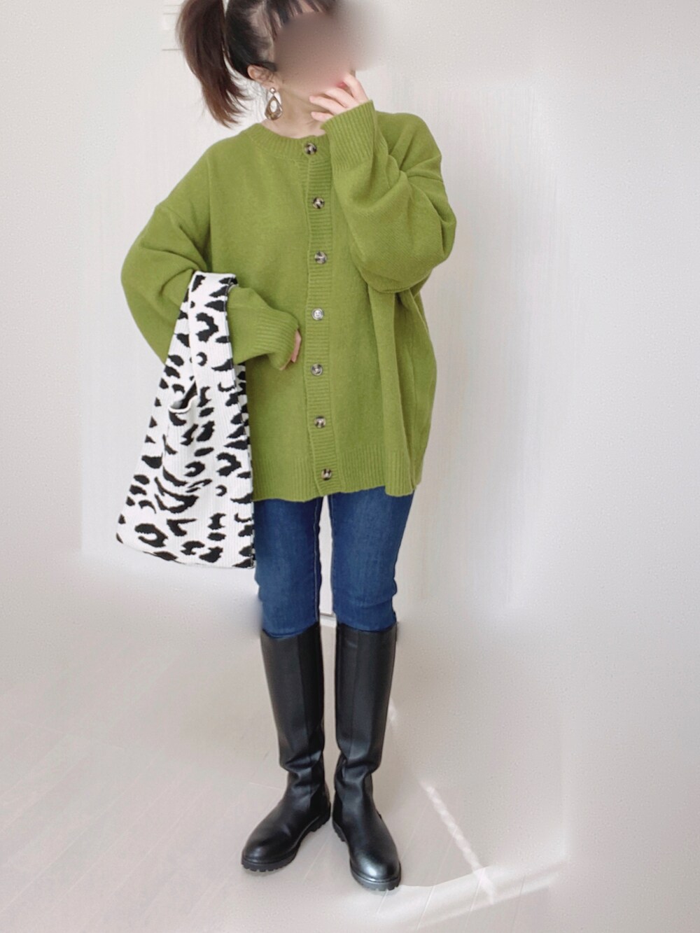 グリーン系のカーディガン/ボレロ、ブルー系のデニムパンツ、ブラック系のブーツを着用したレディースの秋コーディネートの5枚目の写真