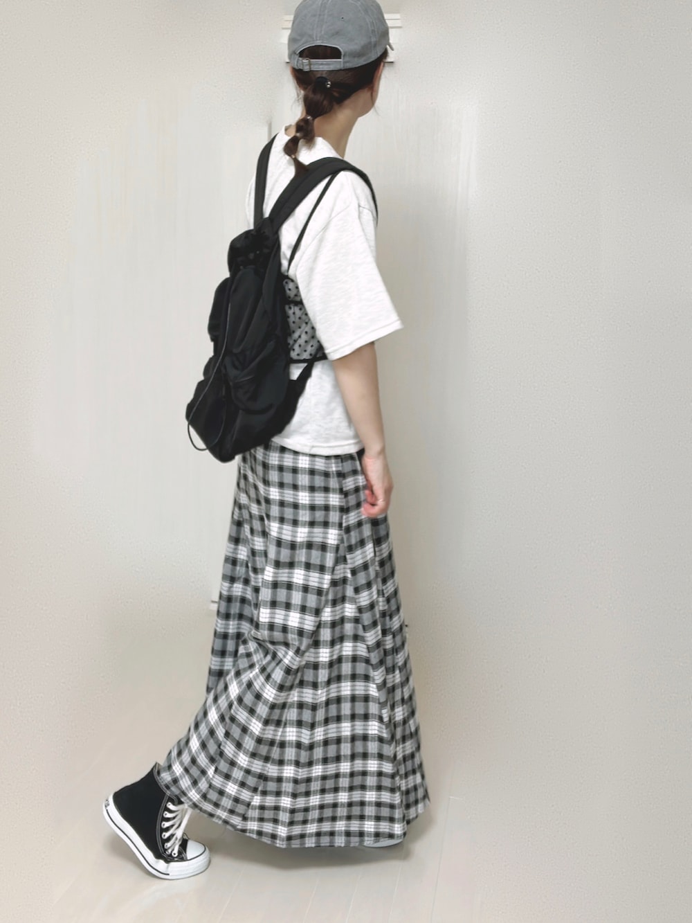ブラック系のバックパック/リュック、ブラック系のスカート、ブラック系のスニーカーを着用したレディースの夏コーディネートの3枚目の写真