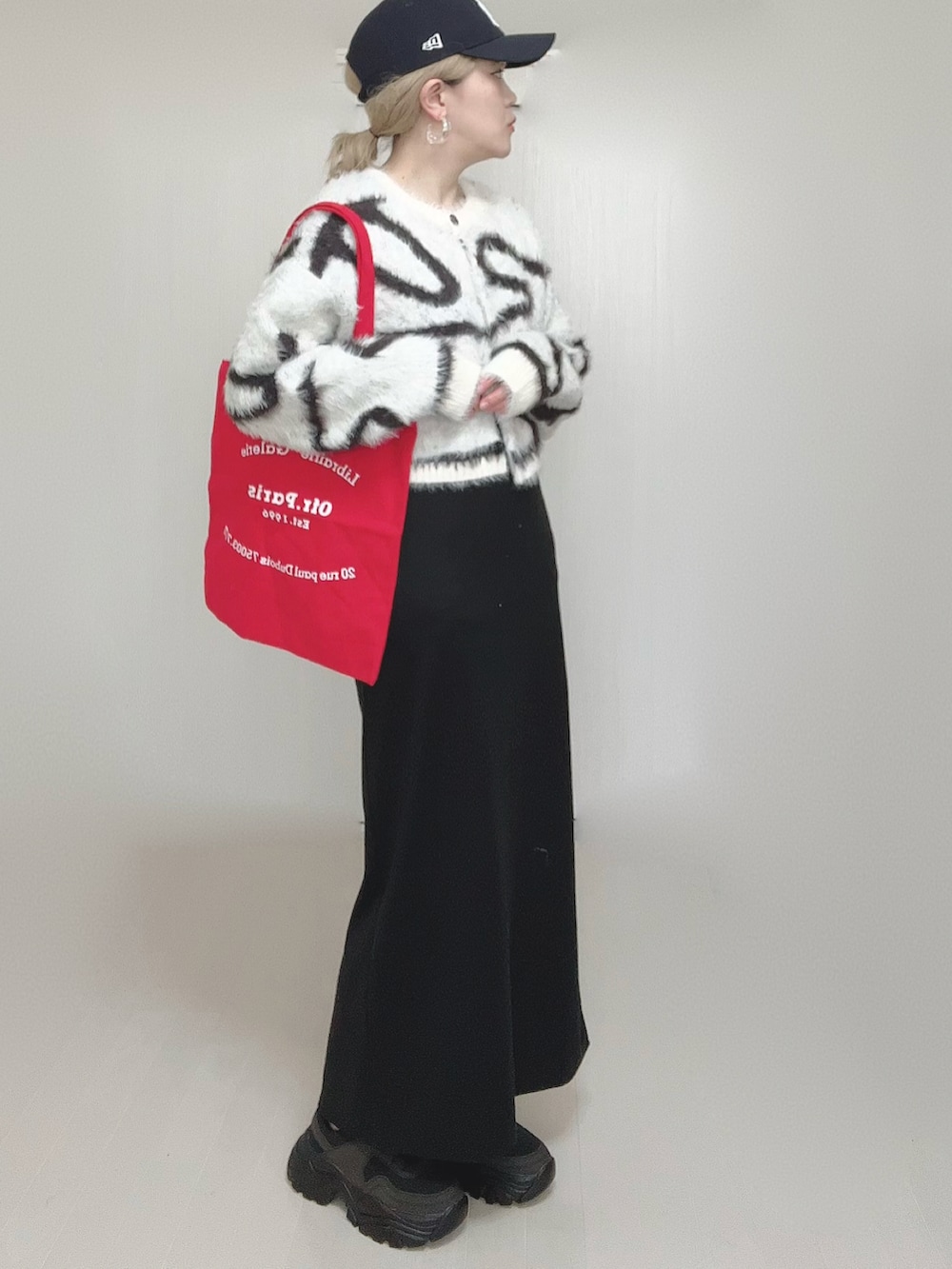 ホワイト系のカーディガン/ボレロ、ブラック系のショルダーバッグ、ブラック系のワンピースを着用したレディースの冬コーディネートの3枚目の写真