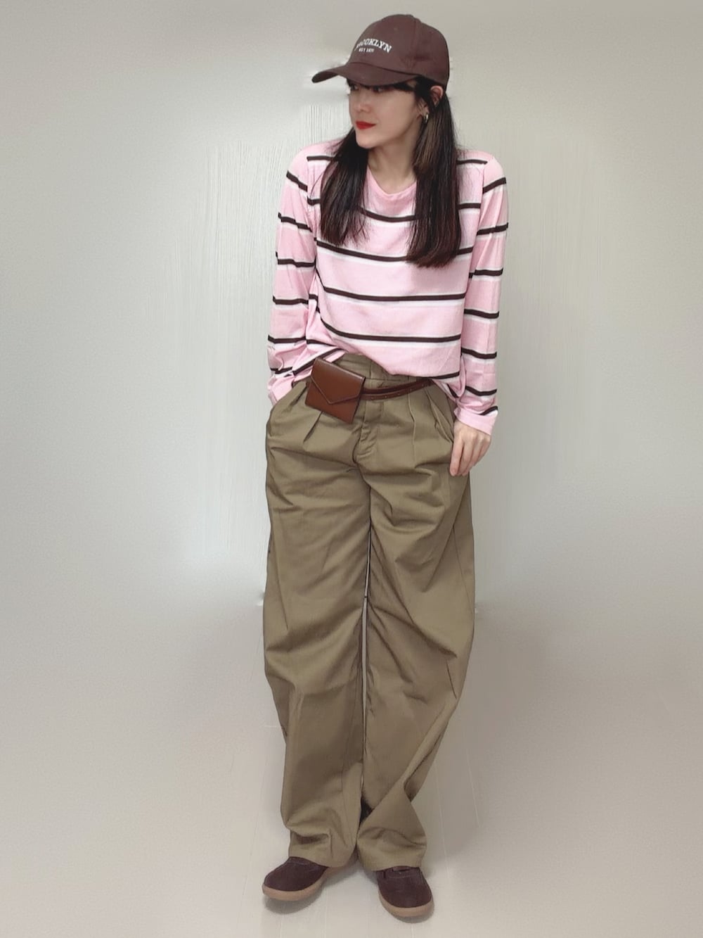 ベージュ系のチノパンツ、ブラウン系のベルトを着用したレディースの秋コーディネートの5枚目の写真
