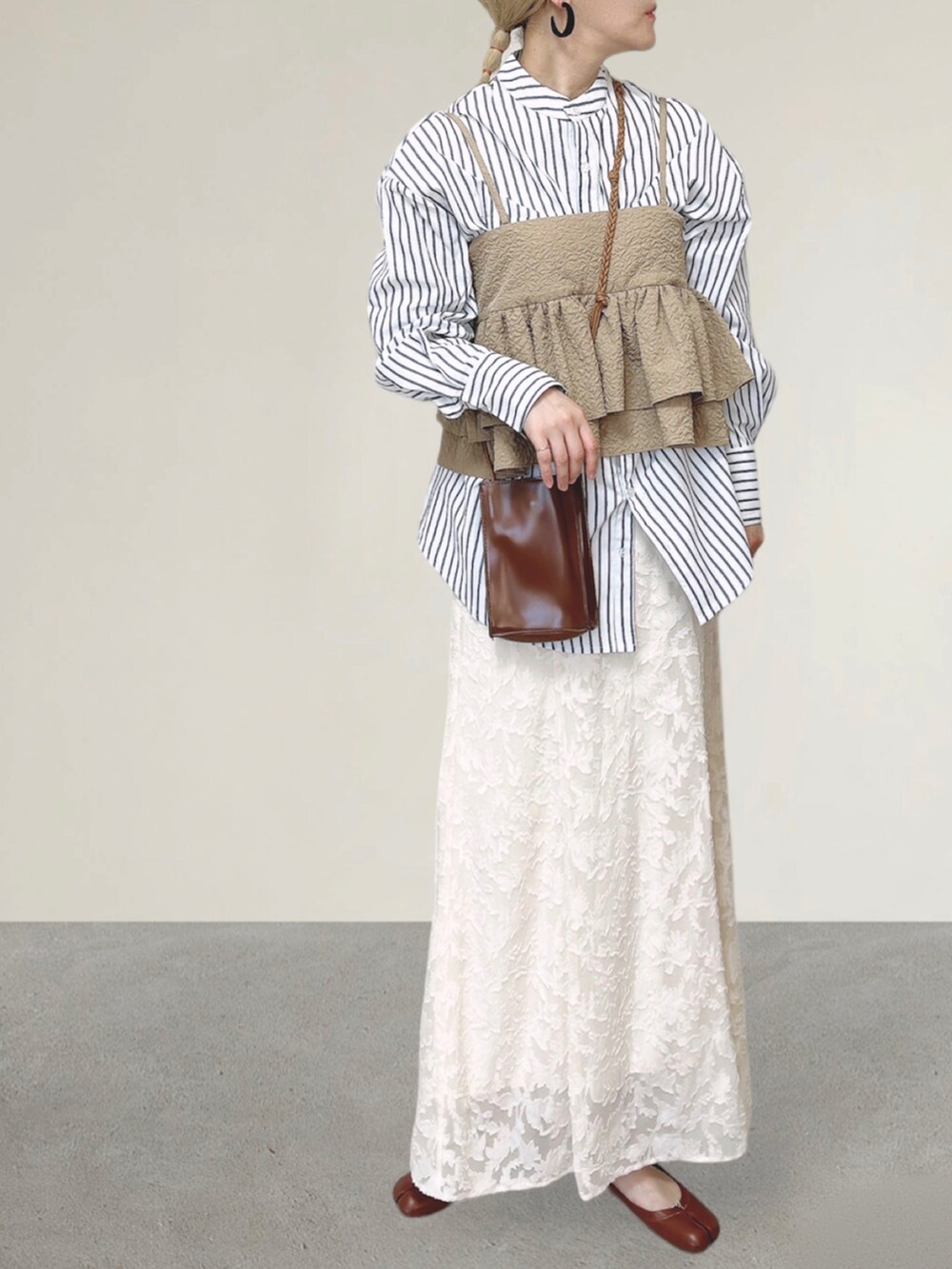 ベージュ系のキャミソール、ホワイト系のシャツ/ブラウス、ブラウン系のショルダーバッグを着用したレディースの秋コーディネートの2枚目の写真