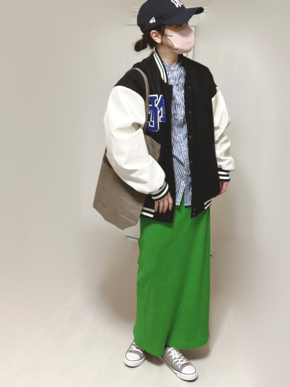 ブルー系のシャツ/ブラウス、ブラック系のスタジャン、ブラウン系のトートバッグを着用したレディースの春コーディネートの4枚目の写真