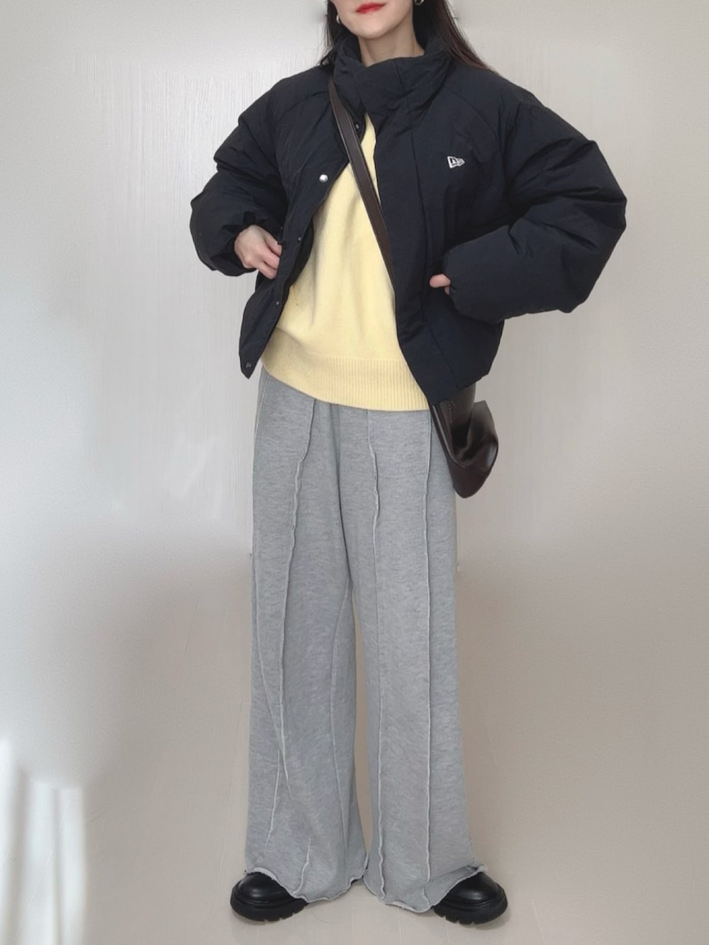 イエロー系のニット/セーター、グレー系のスウェットパンツ、ブラック系のブーツを着用したレディースの冬コーディネートの5枚目の写真