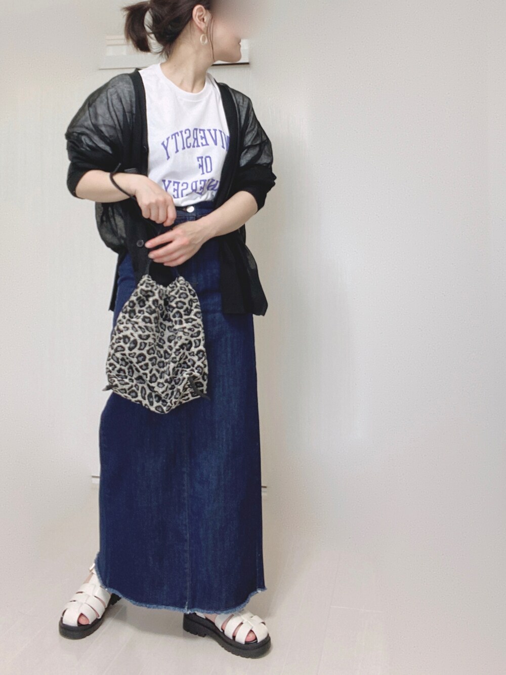 ブルー系のデニムスカート、ホワイト系のTシャツ/カットソー、ブラック系のカーディガン/ボレロを着用したレディースの夏コーディネートの5枚目の写真