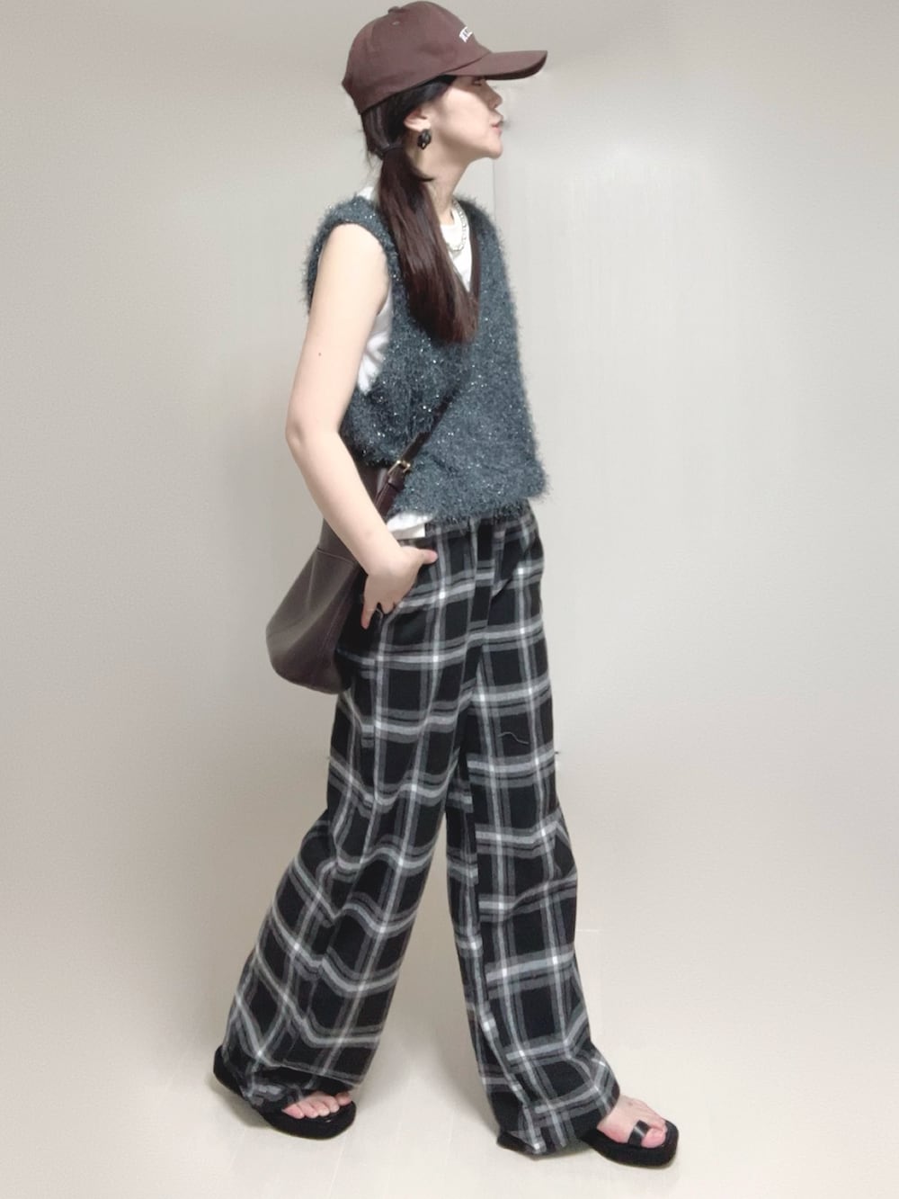 グレー系のベスト、ブラック系のサンダルを着用したレディースの夏コーディネートの3枚目の写真