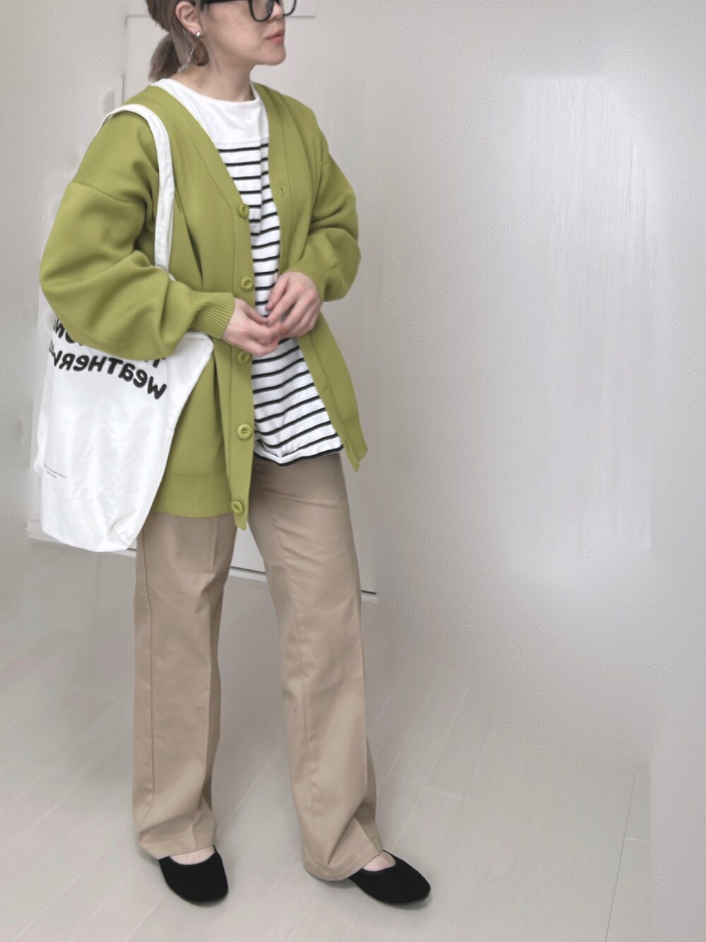 ベージュ系のチノパンツ、グリーン系のカーディガン/ボレロ、ブラック系のTシャツ/カットソーを着用したレディースの冬コーディネートの4枚目の写真