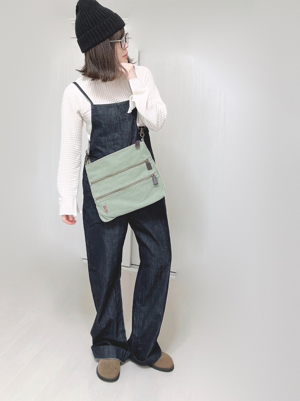 グリーン系のショルダーバッグ、ブルー系のサロペット/オーバーオール、ホワイト系のTシャツ/カットソーを着用したレディースの春コーディネートの3枚目の写真
