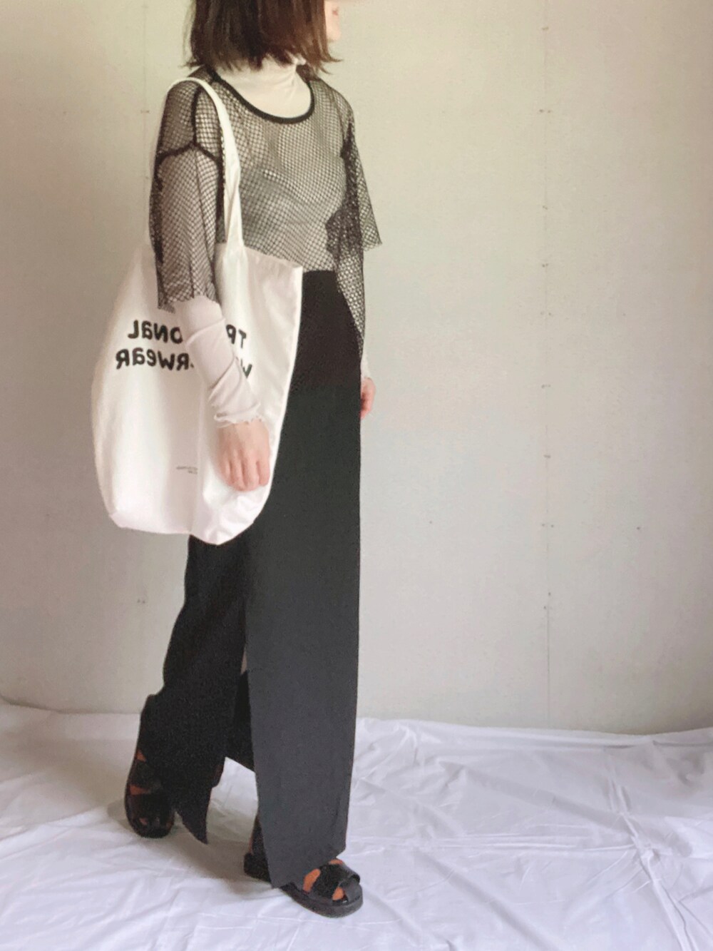 ブラック系のスカート、グレー系のTシャツ/カットソー、ホワイト系のトートバッグを着用したレディースの夏コーディネートの4枚目の写真