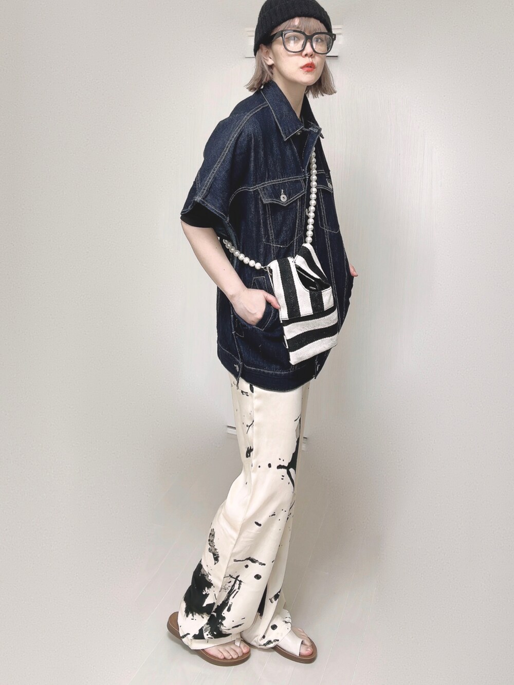 ブルー系のベスト、ブラック系のTシャツ/カットソー、ホワイト系のショルダーバッグを着用したレディースの春コーディネートの3枚目の写真