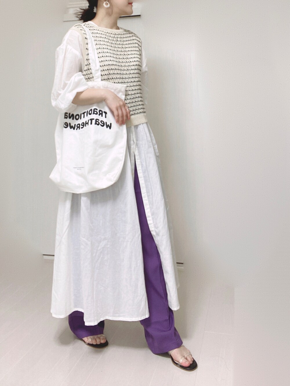 パープル系のスラックス、ホワイト系のシャツワンピース、ホワイト系のトートバッグを着用したレディースの秋コーディネートの4枚目の写真