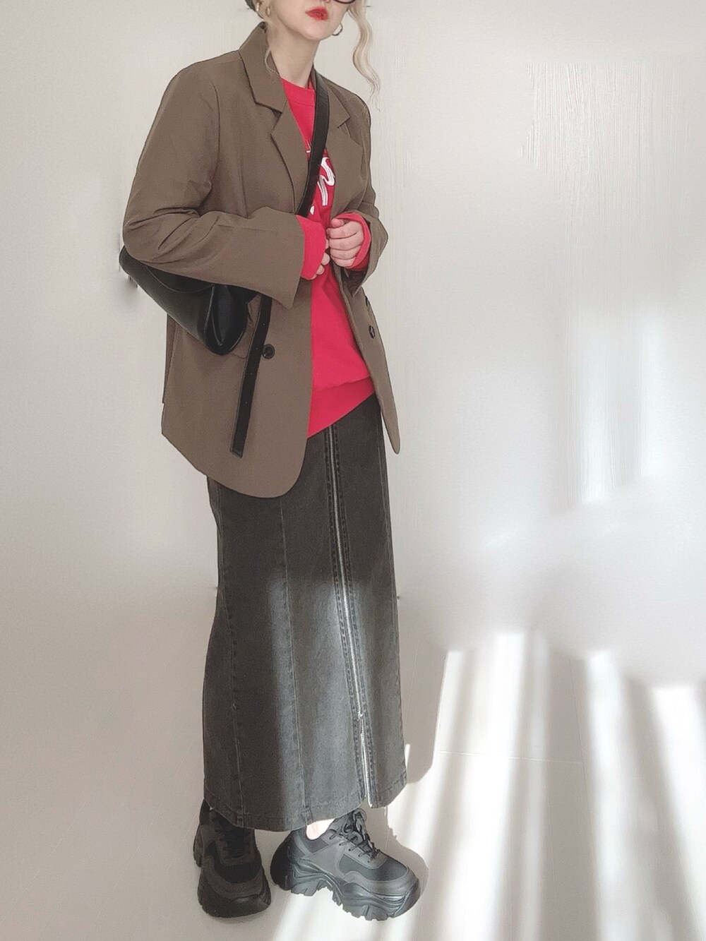 ブラック系のスカート、ブラウン系のテーラードジャケット、レッド系のスウェットを着用したレディースの冬コーディネートの2枚目の写真