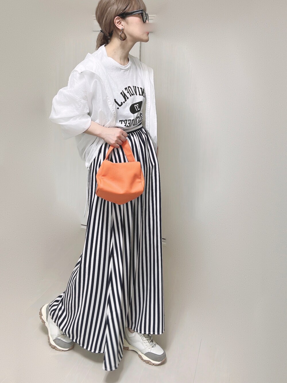 ホワイト系のTシャツ/カットソー、オレンジ系のショルダーバッグ、ブルー系のスカートを着用したレディースの春コーディネートの3枚目の写真
