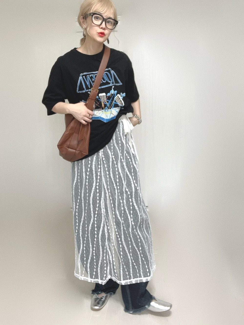 ブラック系のTシャツ/カットソー、ホワイト系のスカート、ブルー系のデニムパンツを着用したレディースの夏コーディネートの5枚目の写真