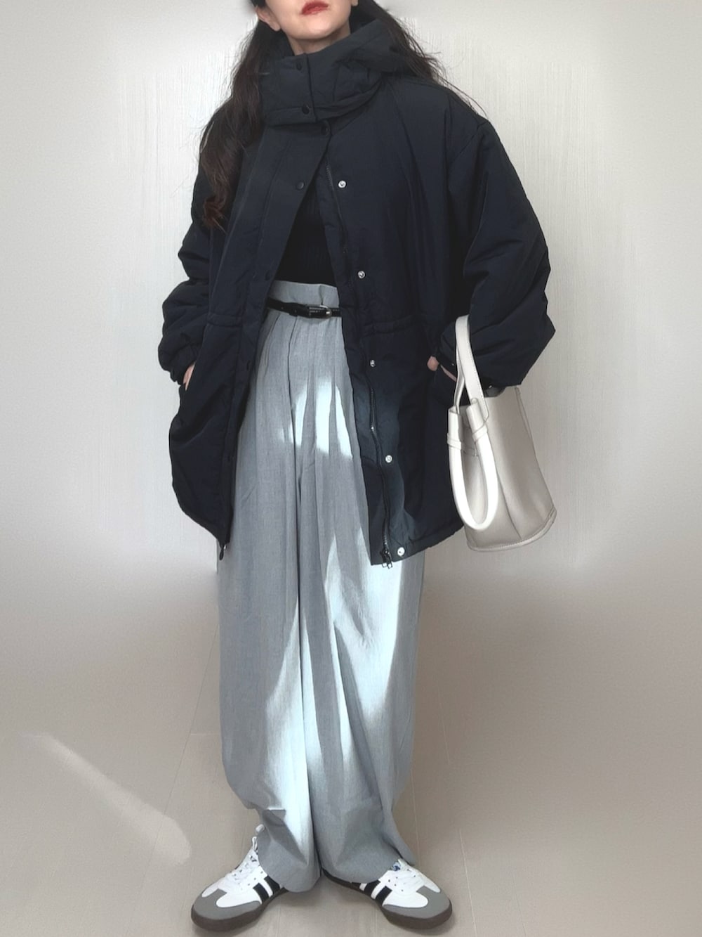 ブラック系のダウンジャケット/コート、グレー系のスラックス、ブラック系のニット/セーターを着用したレディースの冬コーディネートの4枚目の写真