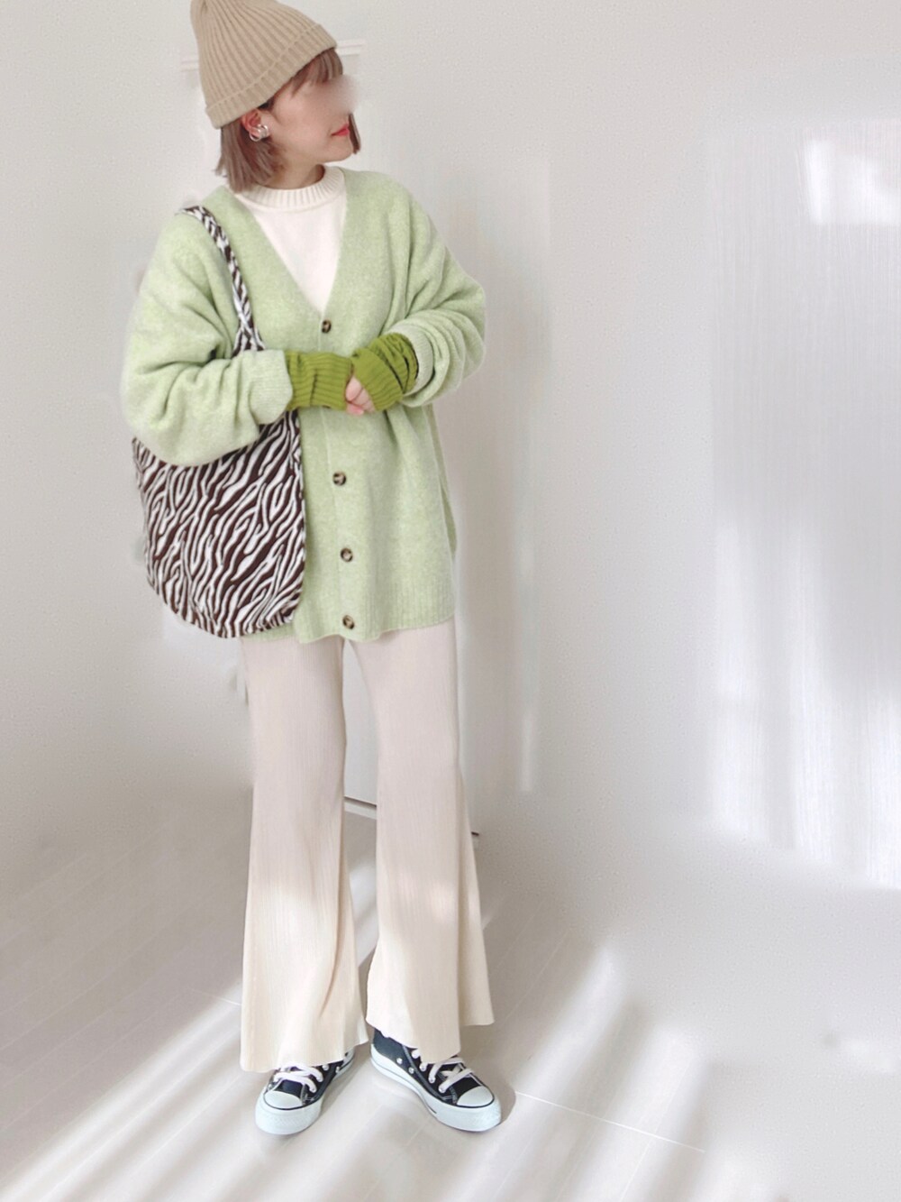 グリーン系のカーディガン/ボレロ、ホワイト系のニット/セーター、ホワイト系のその他パンツを着用したレディースの冬コーディネートの3枚目の写真