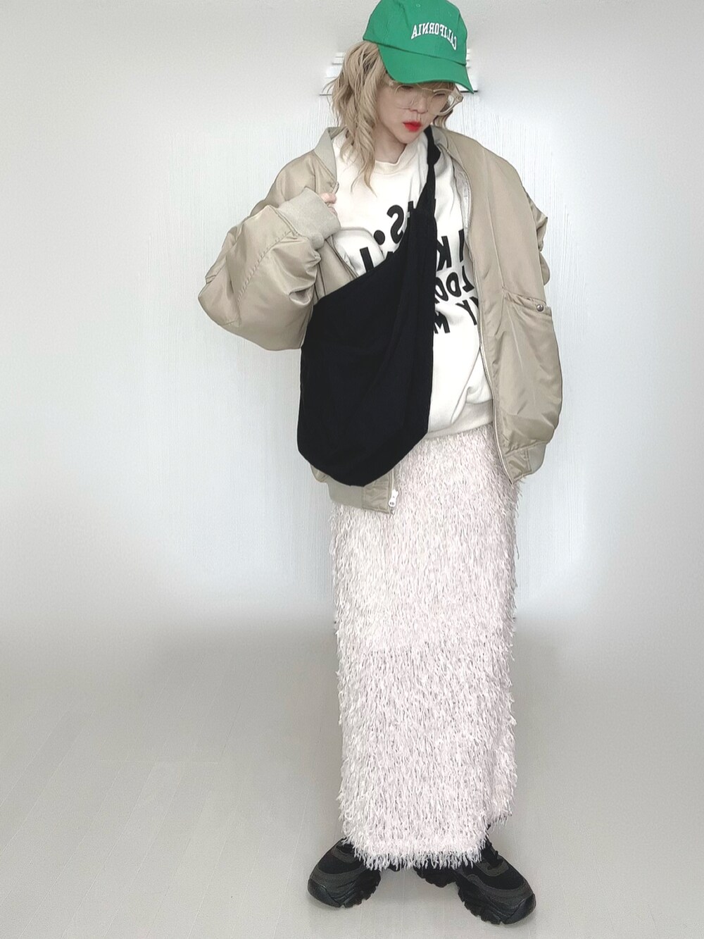 ベージュ系のMA-1、ブラック系のスニーカー、イエロー系のメガネを着用したレディースの春コーディネートの5枚目の写真