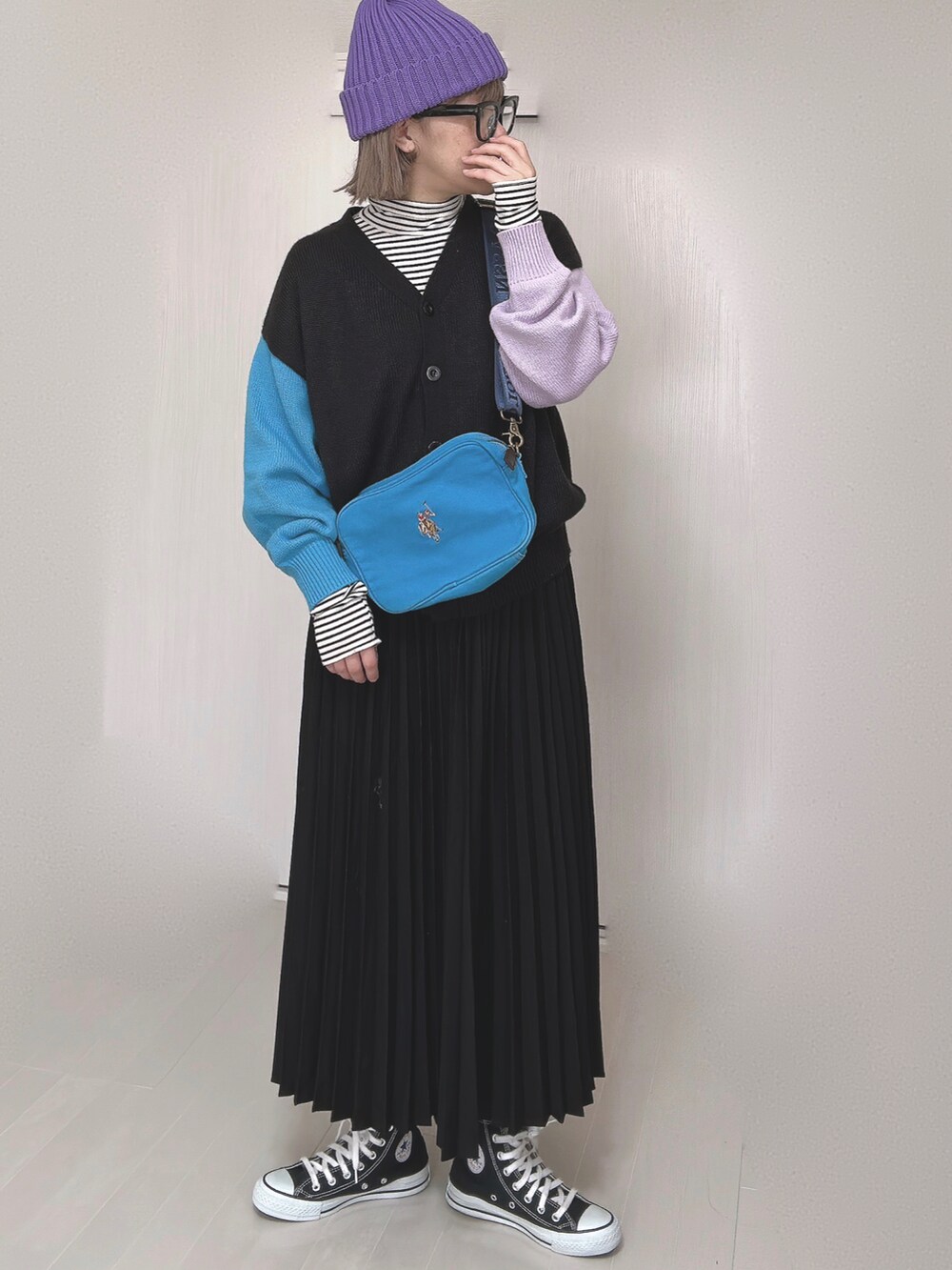 ブラック系のカーディガン/ボレロ、ブルー系のショルダーバッグ、ブラック系のスカートを着用したレディースの春コーディネートの2枚目の写真