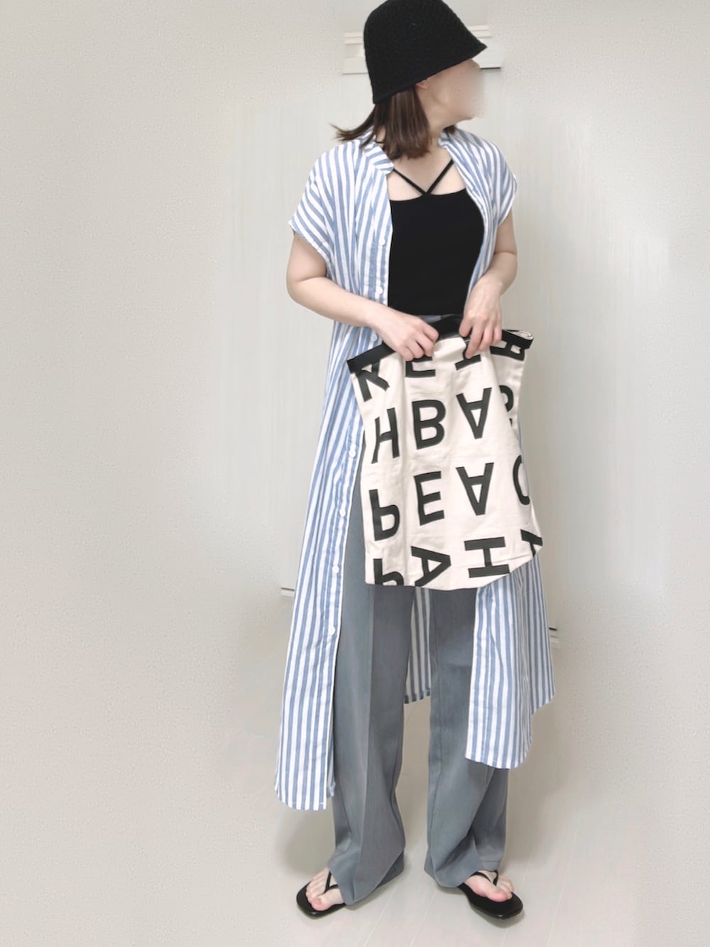 ブラック系のキャミソール、ブルー系のシャツワンピース、ホワイト系のトートバッグを着用したレディースの夏コーディネートの3枚目の写真